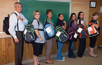 CDEC members showing off the new backpacks for students